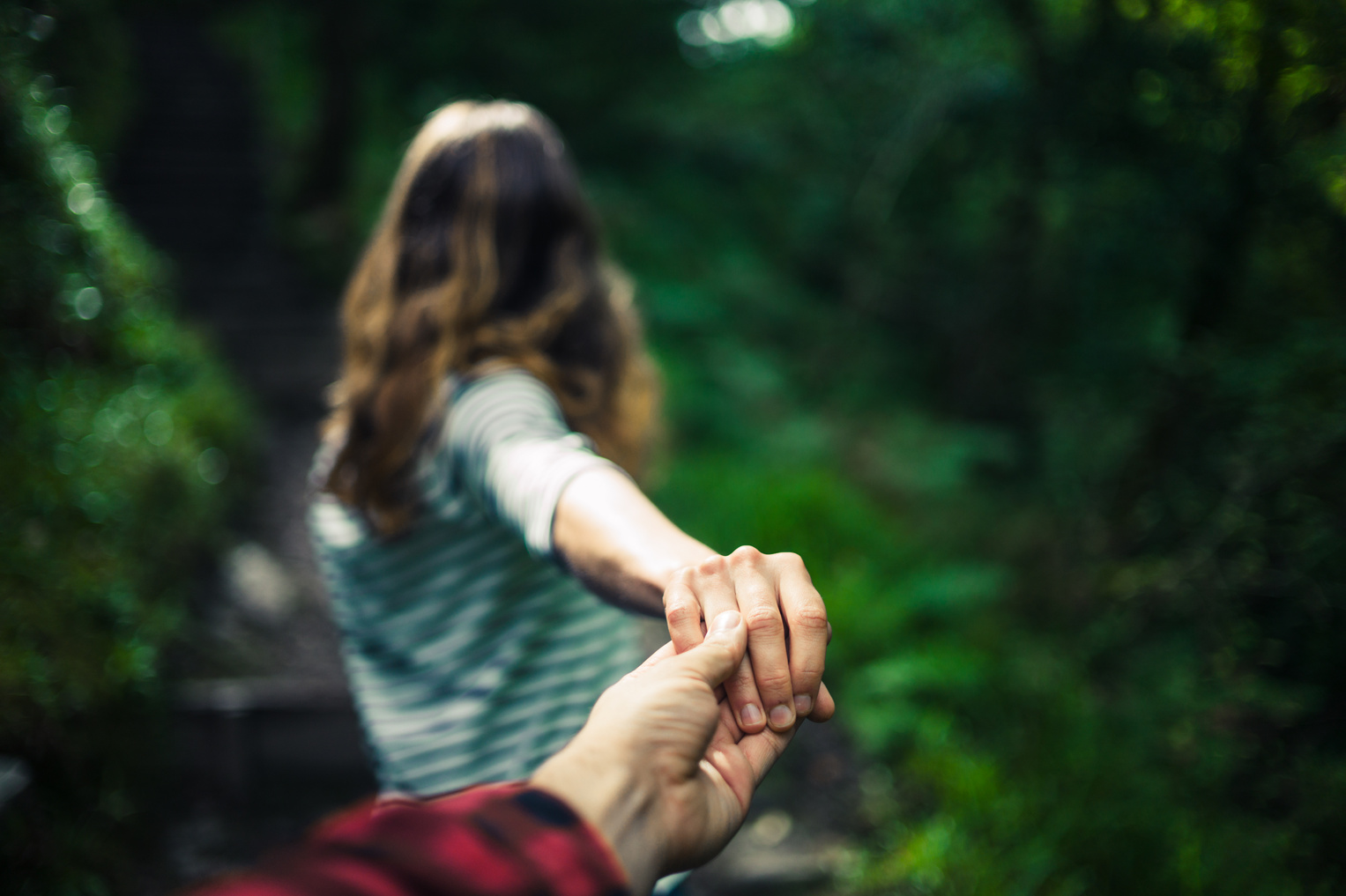 Woman Guiding Her Boyfriend through Forest